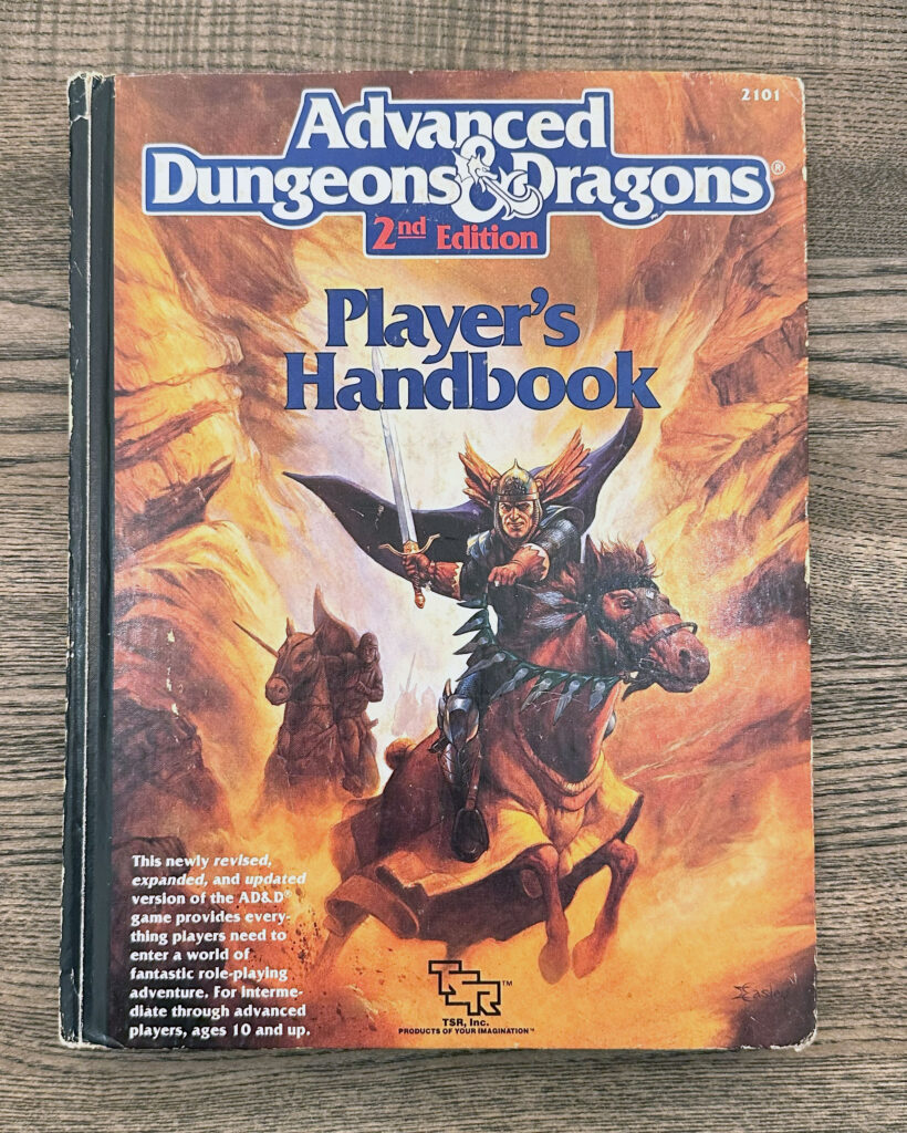 Cover depicting a knight charging on horseback at the reader, with a sword drawn. He's wearing chainmail and a winged helmet, with his cloak billowing behind him. There are more riders behind him, also with swords drawn.