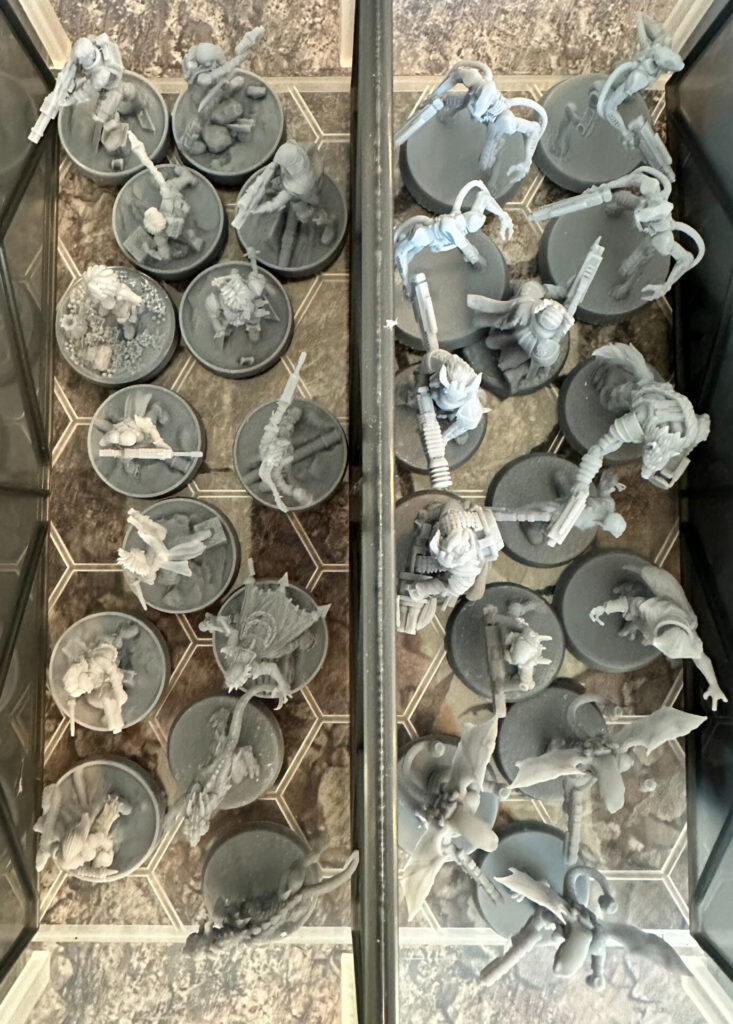 Unpainted, 3D printed, resin, science fiction miniatures in a box. Top down view.