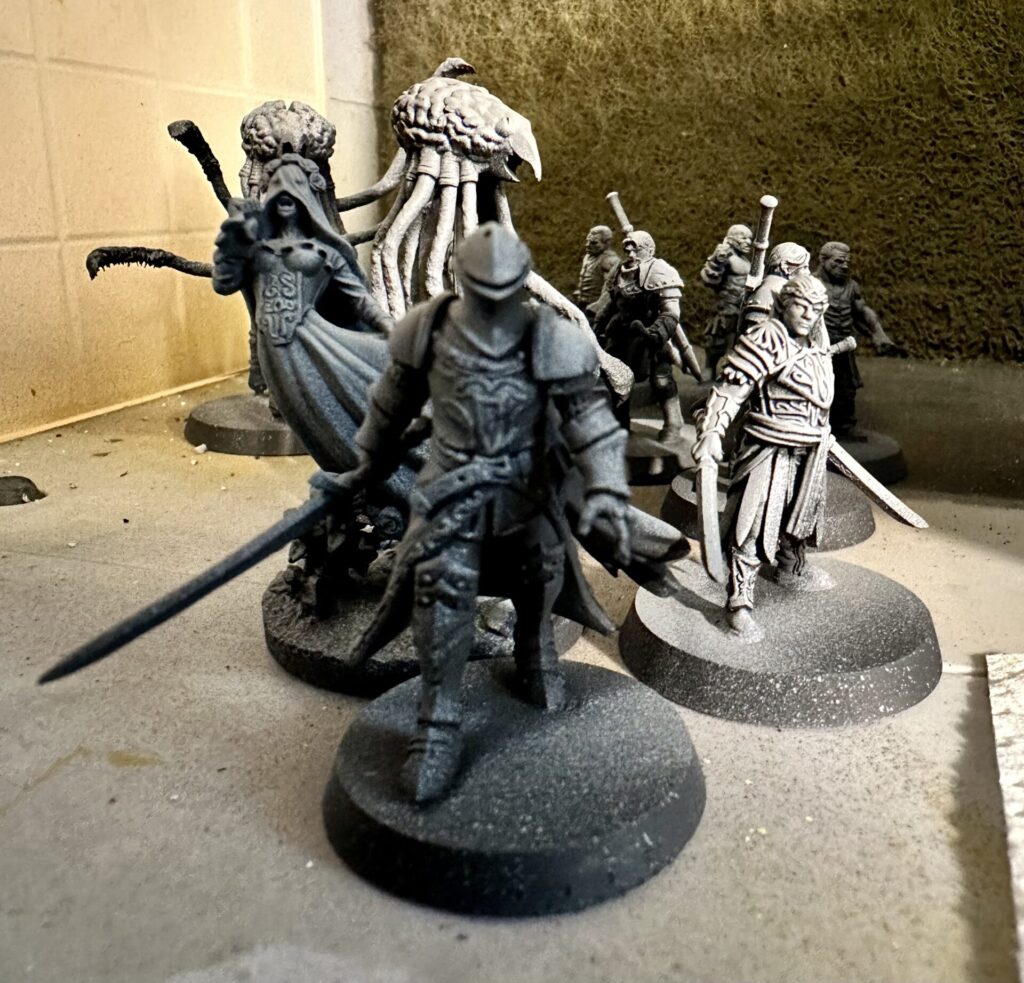 Primed (zenithal style - grey and white for light over black) 3D printed fantasy miniatures. Knight, ghost, couple of grells, elf noble, various thugs and warriors.