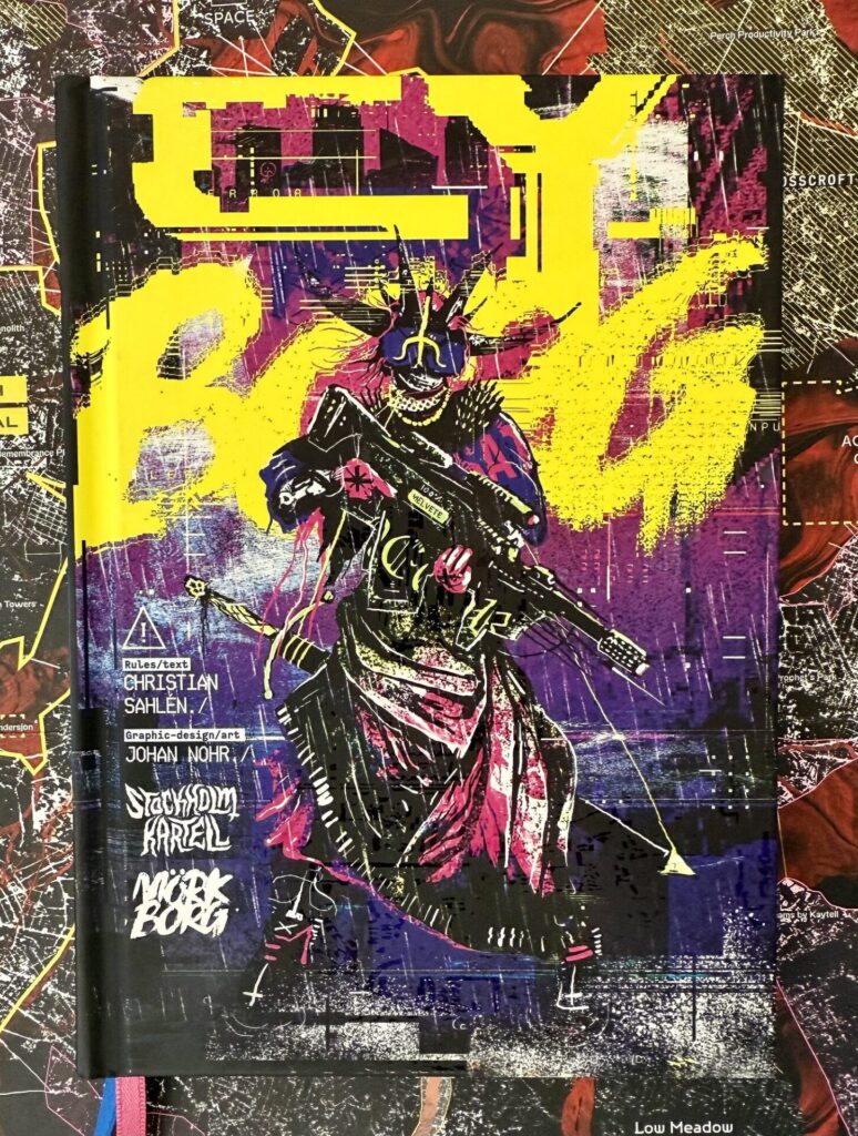 Cover of CY_BORG, depicting a dark cultist type with a horned helmet and a modern assault rifle, carrying a sword. The digitally distorted logo is in bright yellow, with dark blues and purples in the background.